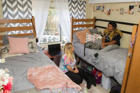 Harrill Residents socializing in their room with two beds in view.