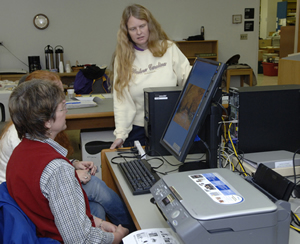 Robin Hitch, Craft Revival’s Technical Support Technician explains the new computer workstation to Suzanne McDowell, Curator at the WCU Mountain Heritage Center