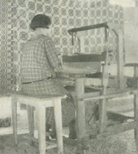 Student weaver in front of coverlet in Chariot Wheels pattern working on newer lightweight loom
