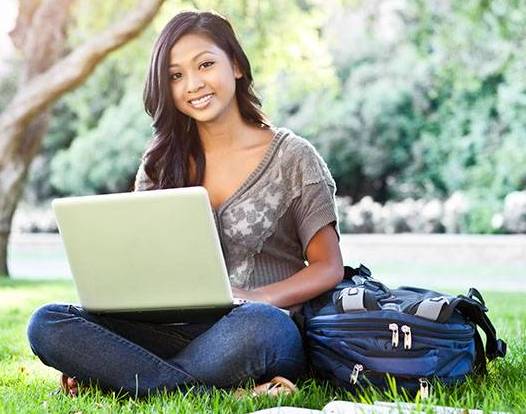 Student studying outdoors with laptop