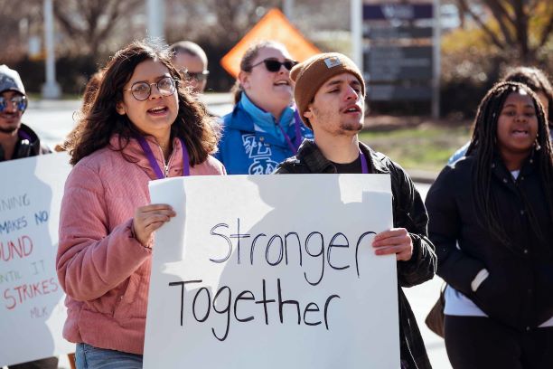 Photo of students during an Mlk Jr. march holding a sign saying 'stronger together'