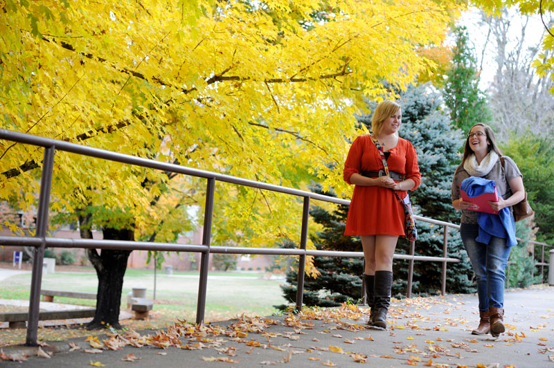 female students walking in the fall on campus