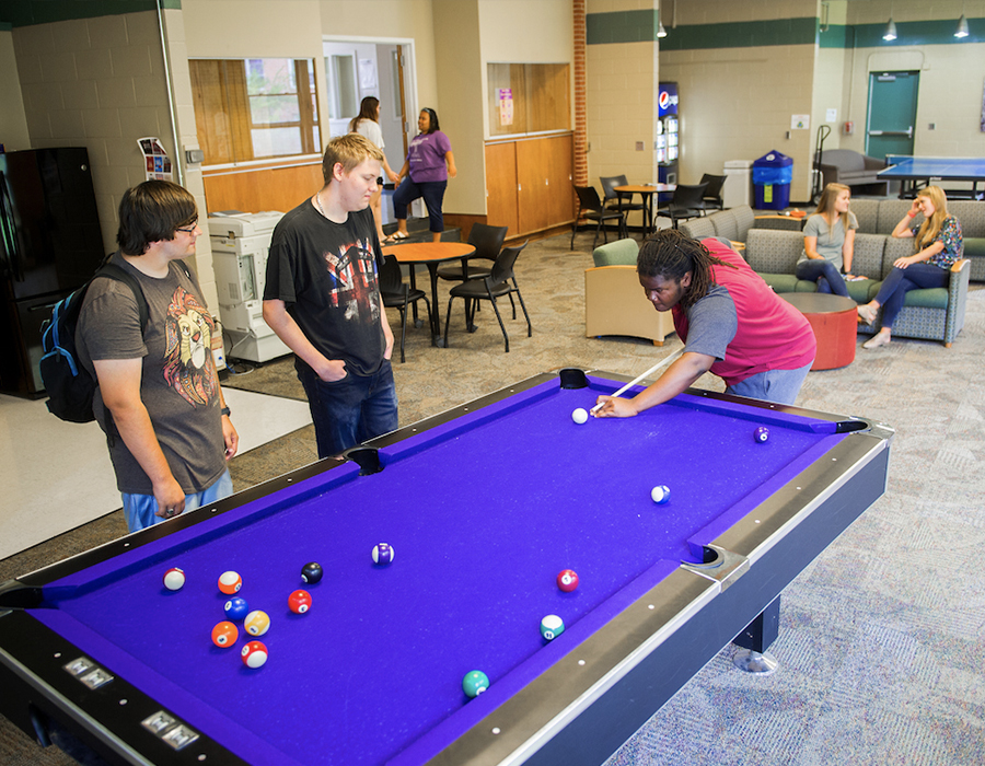 Students playing pool in the common area of albright benton