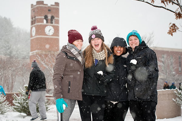 Students in the snow in front of the alumni tower