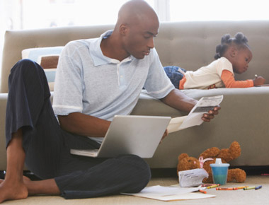  man with a computer and his daughter on a couch