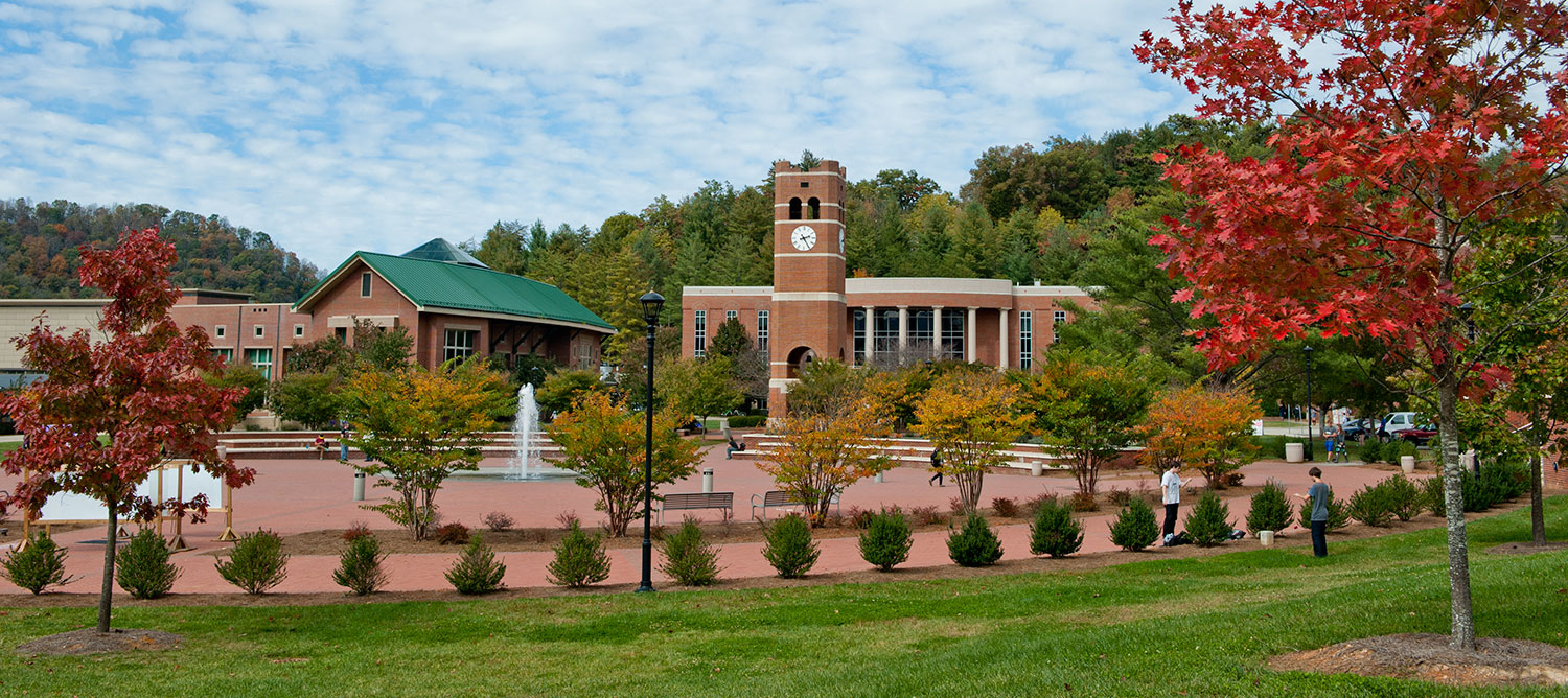 Alumni tower on campus with trees with fall colored leaves
