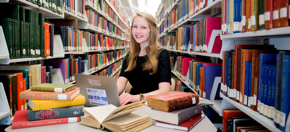English student in the library with several books