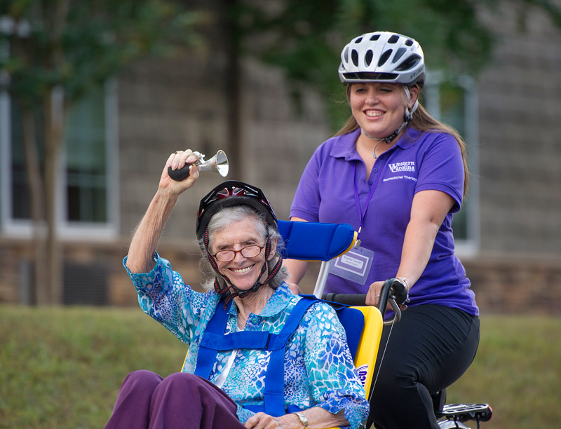 Recreational therapy student giving an elderly woman a bicycle ride
