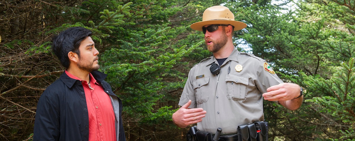 Student talking with Park Ranger in woods
