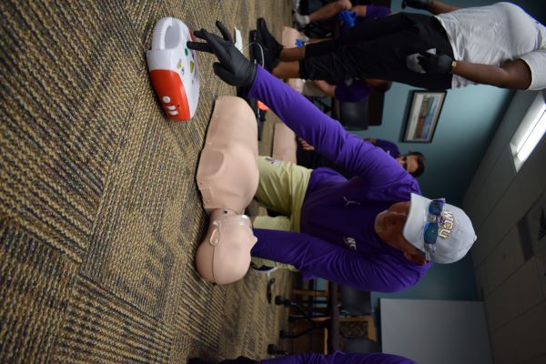 A man preparing to use an AED in class