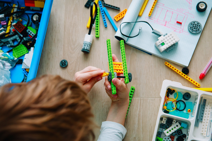 A young boy putting together a lego robotics set