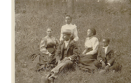 Family posed for a portrait seated on a lawn.