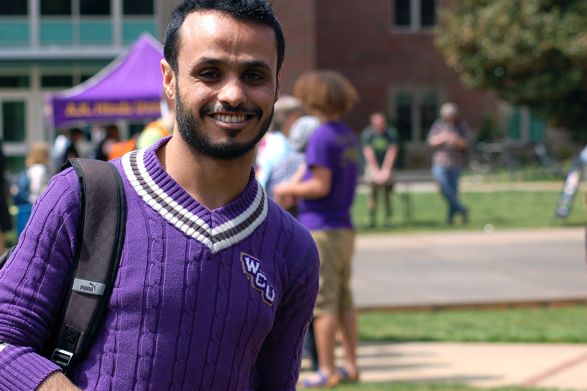 Apply Now Button - Student wearing WCU sweater