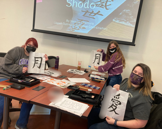 Students practicing Japanese calligraphy