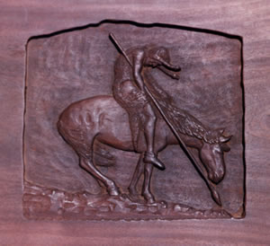 This motif, of an Indian bent worn and weary, is known as End of the Trail. The bas relief was carved in walnut by Goingback Chiltoskey in 1933. Museum of the Cherokee Indian.